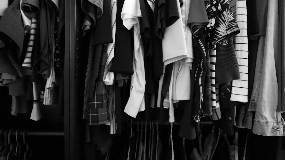 Neatly arranged wardrobe of shirts being reviewed for a keep, donate or sell decision before moving