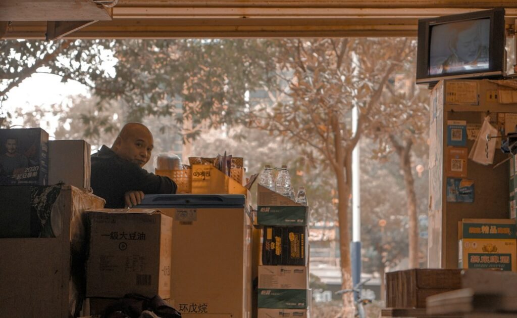 Person sitting beside taped and packed cardboard boxes the day before a house move